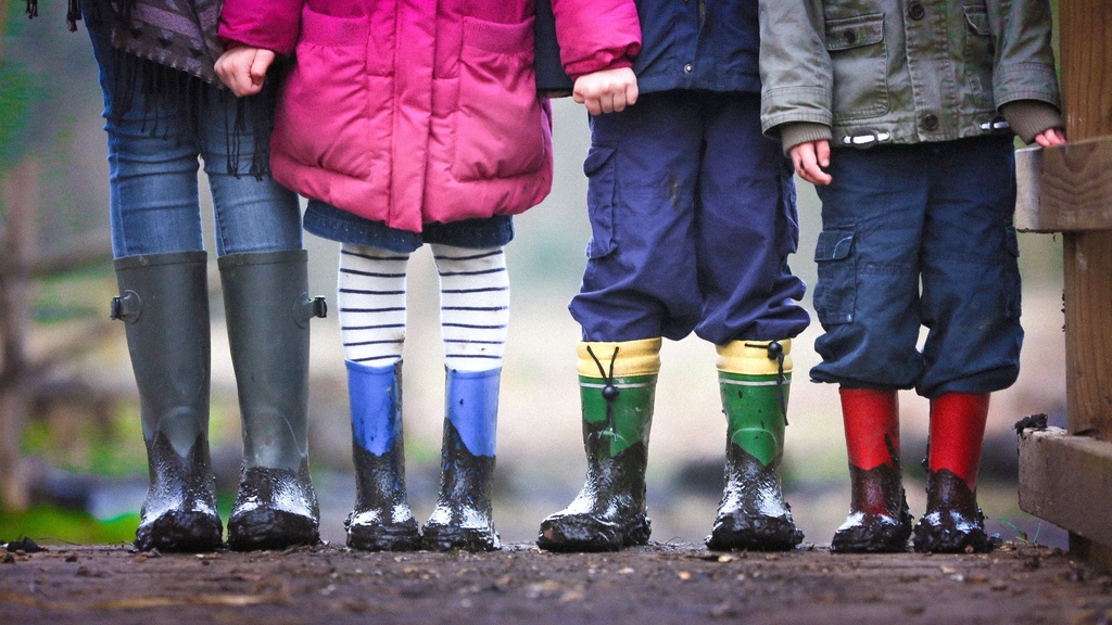 Children in rain boots holding hands